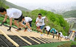 札幌市の大倉山ジャンプ競技場で、ラージヒルを駆け上がる参加者=17日午前