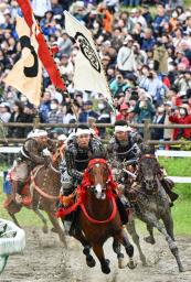 「相馬野馬追」の甲冑競馬で疾走する騎馬武者=25日午後、福島県南相馬市