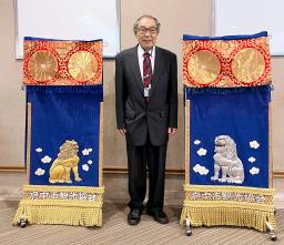 横綱玉の海の三つぞろいの化粧まわしのうち、太刀持ち(左)と露払いのまわしと写真に納まる「第51代横綱玉の海を愛する会」の荒島伸好会長=28日、名古屋市