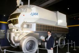 有人月面探査車「ルナクルーザー」の実物大模型。手前は監修を務めた元JAXA主任研究開発員の戸梶歩さん=11日午前、東京都江東区の日本科学未来館
