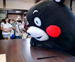 輪島塗の体験施設で箸を制作する「くまモン」=9日午前、石川県輪島市