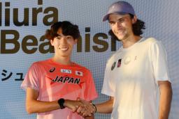 トークイベントに出席し、握手する男子3000メートル障害の三浦龍司(左)とジョーディ・ビーミッシュ=16日、東京都内