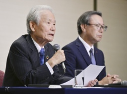 プロ野球オーナー会議を終え、記者会見するNPBの榊原定征コミッショナー。奥は日本ハムの井川伸久オーナー=17日、東京都内