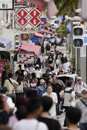 観光客らが行き交う那覇市中心部の国際通り=2024年6月