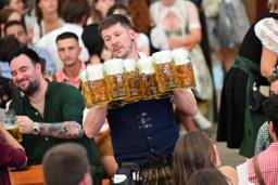 ビールジョッキを運ぶウエーター=20日、ドイツ・ミュンヘン(ロイター=共同)