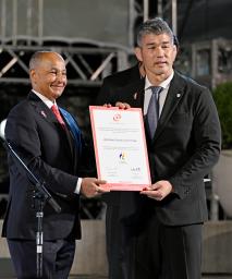 アジア大会1年前イベントで、大会への招待状を受け取る日本選手団の井上康生団長(右)=23日、名古屋市