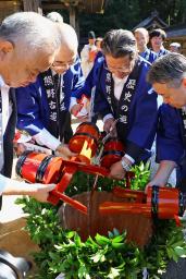 熊野本宮大社の「献湯祭」で本殿前の大だるに温泉の湯を注ぎ入れる宿泊施設の代表者ら=27日午前、和歌山県田辺市