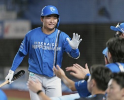 8回、勝ち越し犠飛を放ちナインに迎えられる日本ハム・山県=ZOZOマリン