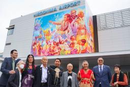 壁画の完成披露式に出席した作者のアドリー・デルロシオさん(左から3人目)とカルロス・アルベルトさん(同5人目)ら=15日午前、広島空港