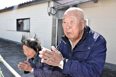 海に向かって手を合わせ続ける清一さん（右）とアキ子さん＝新地町大戸浜