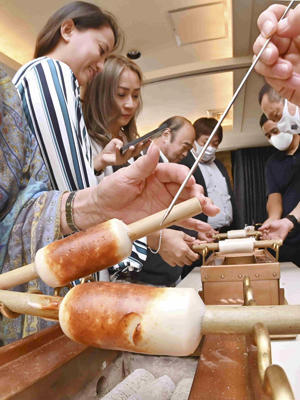 ちくわ焼き体験会で、炭火でちくわを香ばしく焼き上げる参加者＝３０日午後、福島市・中国四川料理石林