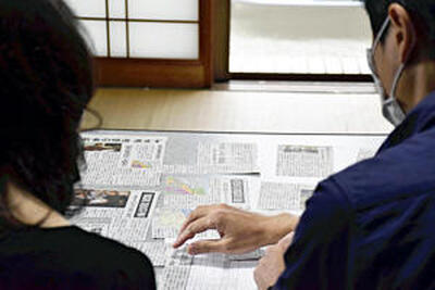 勧奨地点についての記事を眺める夫婦。「時間はたったが、踏み出せていない被災者もいる」と夫婦は訴えている＝南相馬市原町区高倉地区