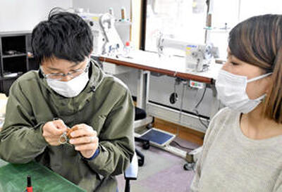 斎藤さん（右）の指導を受け、「イノキー」作りに挑戦する記者。弾力があり、針を通すには力が必要だ