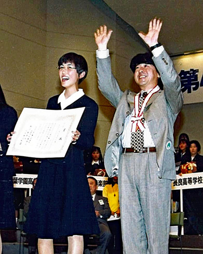 ４８回大会で生徒と表彰される私（右）。この２日後、大賞を受賞して再び舞台に上った。私の失敗に動じなかった生徒が自ら取った日本一だ