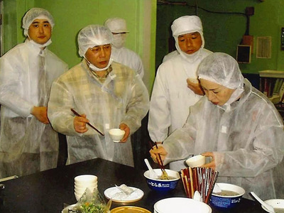私（左から２人目）が監修したカップ麺の試食。試作を重ねて本物の味に近づける。手軽にとら食堂の味が味わえるが、ぜひ白河に来て本物を食べてほしい