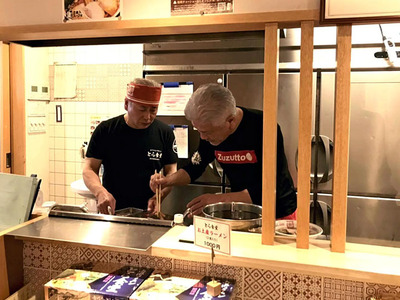 とら食堂唯一の直営店「福岡分店」の調理場に立つ河原さんと私（左）。博多っ子も白河手打ち中華そばの味を認めてくれたようで、繁盛している