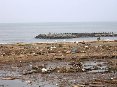 震災から１０日後の北泉海水浴場。砂浜は無残に削り取られ、海岸をがれきが埋め尽くした。変わり果てた姿を目の当たりにし、二度とサーフィンができないと感じた
