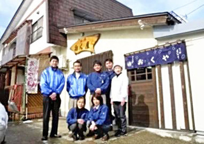 自宅の一部を改修して本社にした。最初は私（後列中央）と妻、社員の３人で始まったが、従業員は徐々に増えて、今では１６人となった
