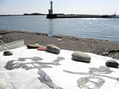 旅で訪れた松川浦の海岸。土地の思いを書に込めるため砂浜の石を文鎮代わりに使い、海面が輝き、心地よい波の音を「波音」という書で表現した