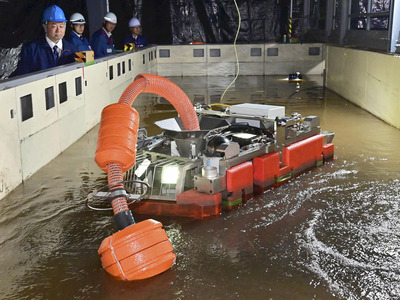報道陣に公開されたゼオライト土のう集積作業用ロボット＝楢葉町・楢葉遠隔技術開発センター