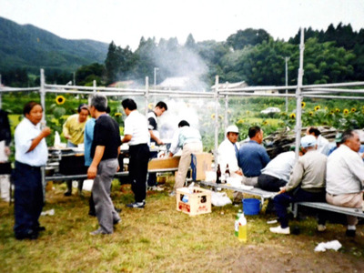 ヒマワリ畑で花見をする地域住民たち。お酒も入り、大いに盛り上がった。ヒマワリ栽培の苦労が報われた瞬間だった