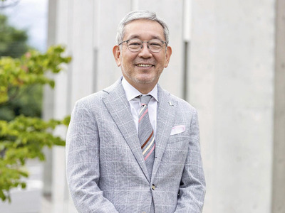 ４年半かけて完成した森の棟の前に立つ私。３０年間、施設整備やさまざまなプロジェクトに取り組んできた