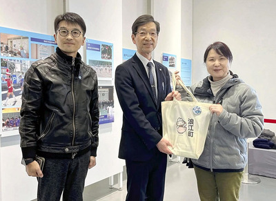 笠井教育長から記念品を受ける小橋さん（右）。左は太見理事長