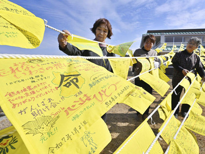 復興への思いなどが書き込まれた黄色いハンカチを準備する人たち＝いわき市・いわき震災伝承みらい館