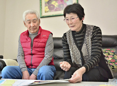 両親と暮らした自宅の写真を見つめる寺島徳男さん（左）と啓子さん。徳男さんは「津波は何もかも無にしてしまった」と話す