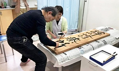 絆診療所の看板は鎌田が書きました。今も新しい絆診療所の玄関に飾ってあります
