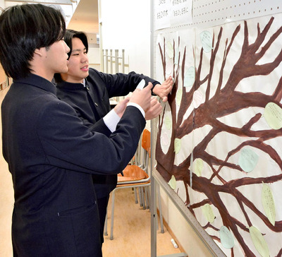 自らの思いを記した木の葉形の色紙を模造紙に貼り付ける生徒