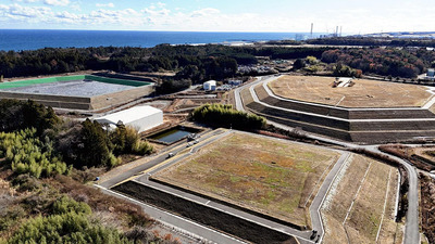 上空から望む中間貯蔵施設。丘のように見える施設８カ所で大量の除染土壌が保管されており、政府は２０年以内の県外最終処分を約束する