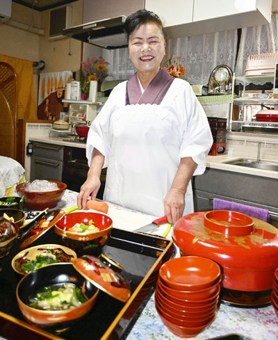 自宅の台所で料理を作る私。義母から受け継いだ郷土料理の魅力を伝えていきたい