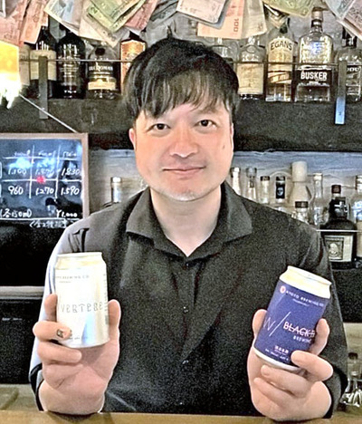 クラフトビールを手に来場を呼びかける紋波さん