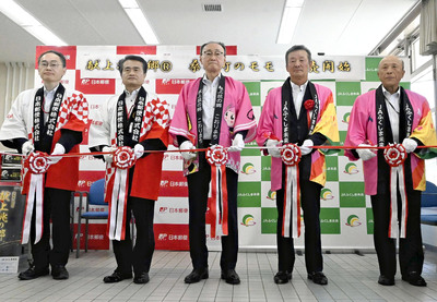 テープカットでカタログの販売開始を祝う神藤局長（左から２人目）ら