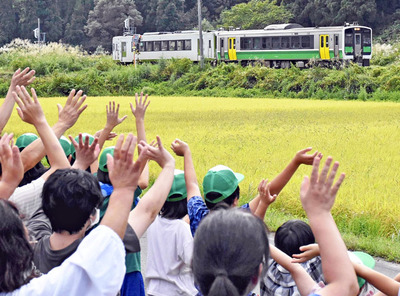 只見線こども会議の途中、列車に手を振って見送る子どもたち。子どもたちの只見線活性化のアイデアはすでに実現しているものもある