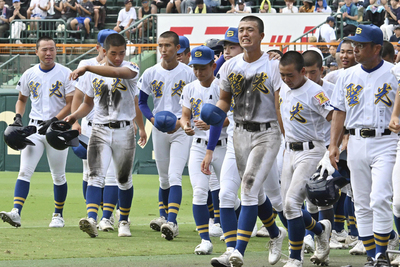 山梨学院に敗れ、一塁側応援席にあいさつした後、悔しい表情を見せながらベンチに戻る聖光学院ナイン＝１２日、甲子園球場