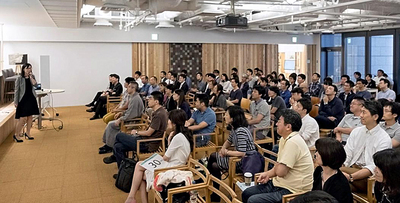 修士論文の発表会で、１００人の生徒の前で事業承継に関する内容を説明する私（左）。同期は、大企業の部長クラスやキャリア官僚など優秀な方々が集まっていた