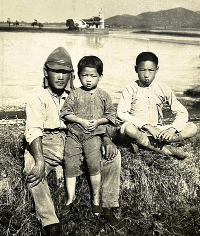 中国で現地の子どもと写真に納まる藤田さん（左）。終戦後は中国国民党に協力した＝１９３９年ごろ