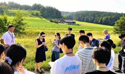 最終処分場の地上施設の建設予定地を視察する高校生。現在は農村地帯が広がっており、唯一の住宅１軒はすでに立ち退いたという＝１３日午後