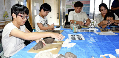 双葉町の土を調合した粘土に触れ、作品作りに取り組む参加者