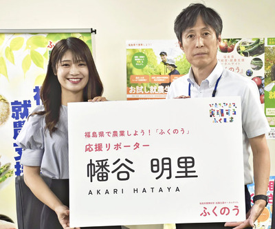 岩沢課長から応援リポーターの名刺を受ける幡谷さん（左）