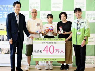 高村館長（右）らから記念品を贈られた門脇さん一家