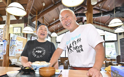明るい笑顔で来店者を迎える店主の高間舘賢一さん（右）と妻美穂さん