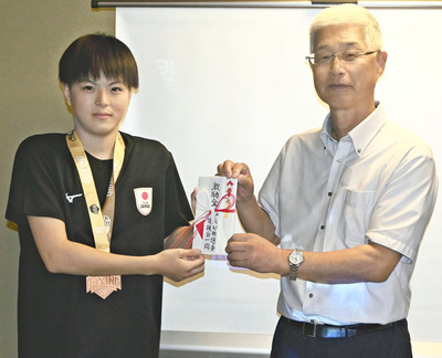 目黒会長から激励金を受けた伊藤さん（左）