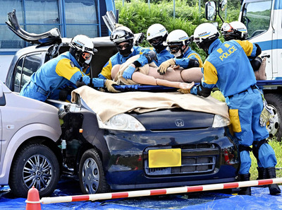 車の窓や屋根を切って要救助者の救出訓練をする警察官＝３日午後、福島市