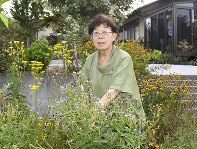 自宅の庭に植えた花々の手入れをする高原さん。「この１０年で町は生まれ変わった」と振り返る