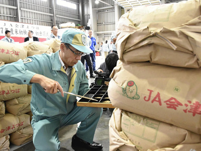 出荷前の会津産「ひとめぼれ」を検査する担当者