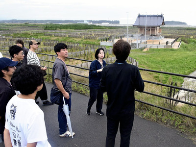 津波被害を受けた神社や海岸を見て回り、作品の構想を深めた参加者＝浪江町