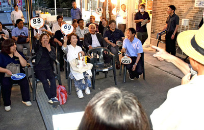 にぎわいを見せたせり市のプレイベント。参加者は欲しい商品が出ると、うちわを挙げてアピールした